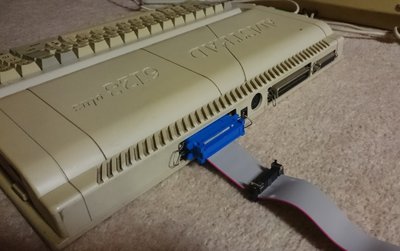 Câble adaptateur branché sur le port d'extension d'un Amstrad CPC 6128 Plus, relié à un lecteur de disquettes 3,5 pouces