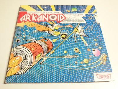 Jaquette du jeu Arkanoid, édition Taito, avec un vaisseau spatial futuriste sur fond bleu