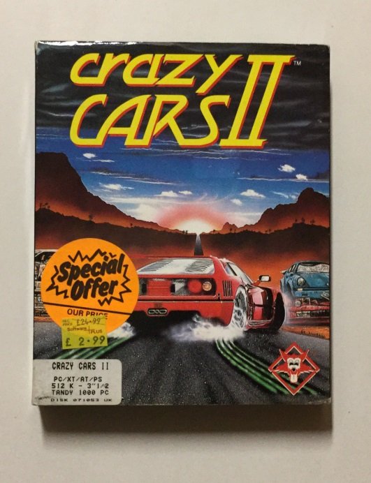 Boîte de la version PC/Tandy de Crazy Cars II, illustrée d'une Ferrari F40 rouge poursuivie sur une route au coucher du soleil