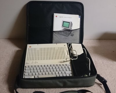 Apple IIc rangé dans sa mallette de transport d'origine avec son guide utilisateur et son alimentation