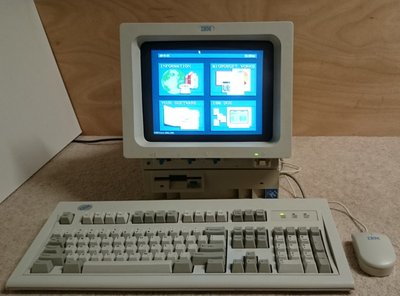 IBM PS/1 avec écran intégré affichant le menu principal, clavier et souris IBM d'origine
