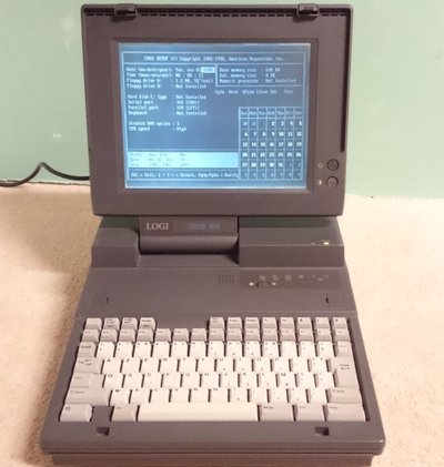 Logi 386 SX ouvert affichant l'écran de configuration du BIOS, clavier azerty et logo LOGI 386 SX visible sur le capot