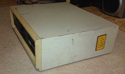Boîtier beige d'un Compaq Deskpro 286 fermé, portant un autocollant humoristique, posé au sol avant démontage