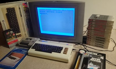 Commodore VIC-20 avec écran affichant l'invite BASIC, lecteur de cassette et collection de cartouches